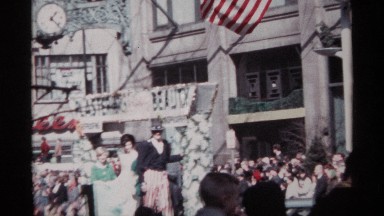 1968: a float carrying a miss beauty pageant is seen moving along a street in