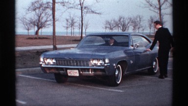 1968: Elegant Man in Black Suit Opens Driver Car Door and Joins Passenger