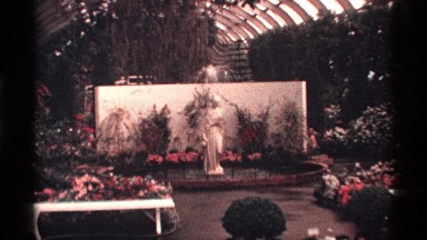 1968: a flower garden with beautiful flower collections and a statue at the