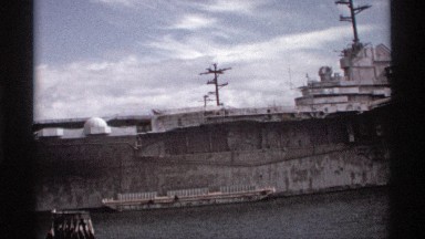 1974: an old wwii era battleship docked next to a submarine, seen at daytime