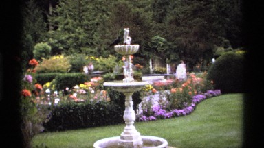 1974: beautiful fountain surrounded by flowers and tourist taking pictures