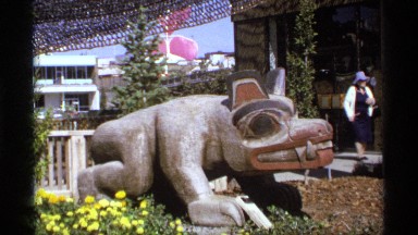 1974: couple walks by animal sculpture that is crouching forward on ground