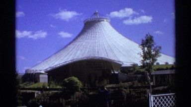 1974: a male taking a photo in front of an interesting looking white building on