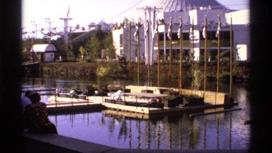 1974: a public dock near a business being visited by a playful couple who are