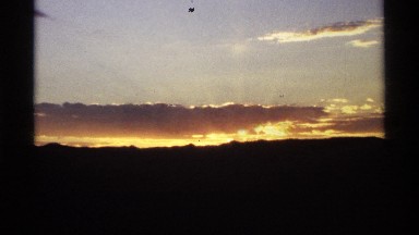 1974: Distant Horizon Showing a Dark Land Mass and the Sun Going Down Behind