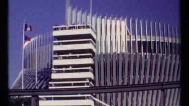 1967: tram passing by stadium flying french flag against blue sky MONTREAL