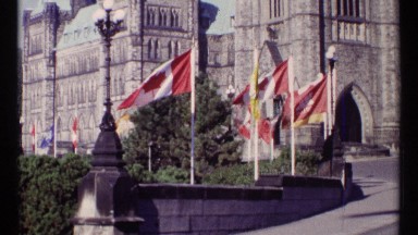 1967: Red and White Canadian Flags Wave in the Breeze on a Bright Day in Ottawa