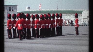 1967: royal guards wear red and black uniforms while standing at attention