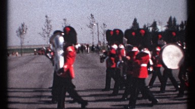 1967: a band playing instruments is marching across an open area outside OTTAWA