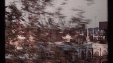 1967: driving past asian style buildings with tourist walking down sidewalk