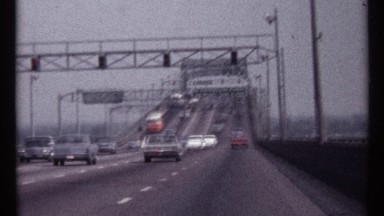 1967: busy traffic heading up the bridge to get over the water. there is a steep