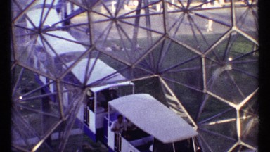 1967: a long passenger train pass under a metal structure in an city. MONTREAL
