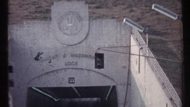 1967: cars and trucks entering a tunnel entrance. flashing lights indicating to