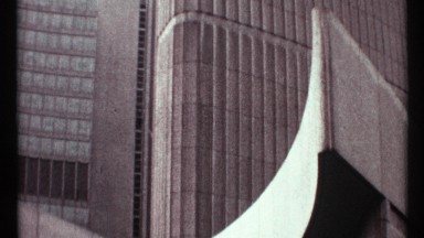 1967: sharp curve of structure is in front of ridged and windowed buildings