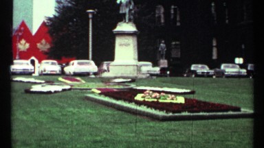 1967: a garden with flower decoration and it full of grass a statue also there