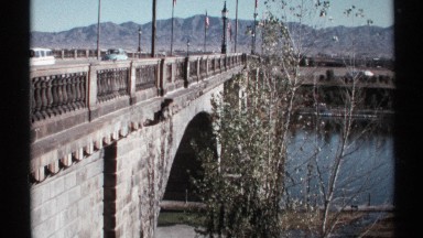 1972: many different sized cars drive on the bridge outside where there are no