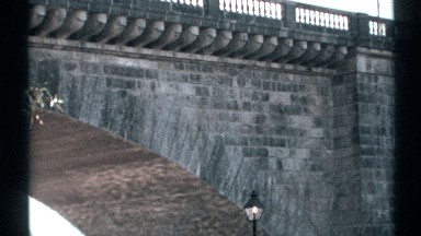 1972: Sunlight Reflects Off Water and Shines Upward Under a Grey Stone Bridge