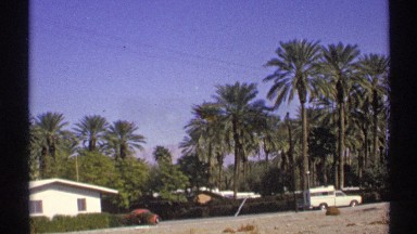 1972: a small house with a car and a beautiful nature background and sand road