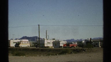 1972: sunny day blue sky beside a highway car passing over a highway, at