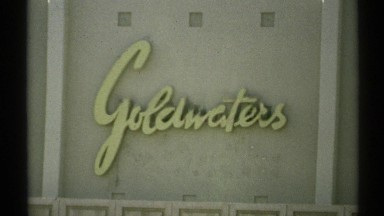 1972: a video of the goldwaters sign and the outside car park which is filled