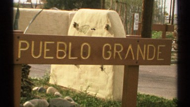 1972: this is a wooden sign that reads "pueblo grande" surrounded by some grass