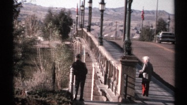 1972: an older lady walks on a bridge as the older man stands nearby. ARIZONA