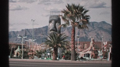 1972: at a road car moving and other side a park that having statues and trees