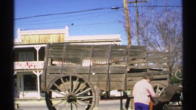 1972: in an old western town a woman enjoy viewing the old fashioned stagecoach.
