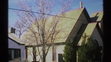 1972: a side view of the house in fall without trees on the leaves, blue skies