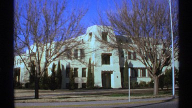 1972: big organisation with front side tree and cloudy environment,road passing
