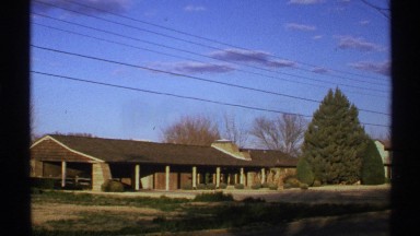 1972: a house with roof and some trees are surrounding the house at the morning