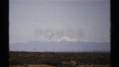 1972: clear sky over a snow capped mountain with some posts and wires in the