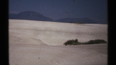 1972: dark object lies across snowy slope with fuzzy texture on both ends NEW