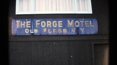 1971: a blue color background board that mentioned a name of forge motel at the