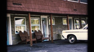 1971: a small line of apartments wait quietly for human activity on a nice day