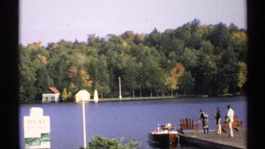 1971: people standing at the end of a dock holding fishing poles. NEW YORK