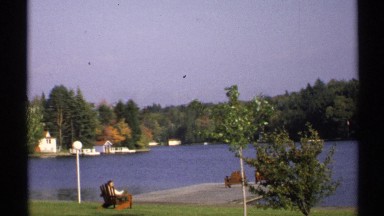 1971: a river and surrounding of trees and plants a lady sitting there at chair