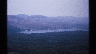 1971: a cute nature with full of grass and water with plants and the sky looking
