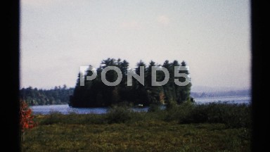 1971: Shiny Day with White Sky and Blue Water Area, an Island with Trees Visible