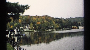 1971: Serene Lake, Still Water, Large White Hillside Home, and Covered Dock