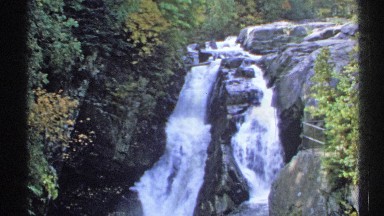 1971: beautiful waterfall, with water flowing down rocks into river. NEW YORK