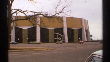 1972: building supports hold elevated gold band over yellow and brown panels