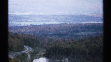 1971: this is a bird's eye view of a vast stretch of forest with a winding road