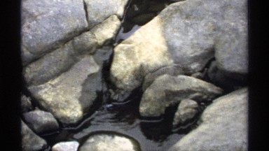 1971: water are flooding between the rock at the mountain and it looks pure