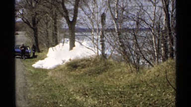 1970: man and woman walk away from blue car parked on side of country road