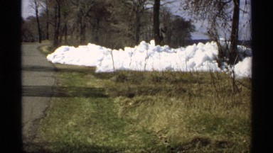 1970: grass by the lake partially covered in snow. MINNESOTA