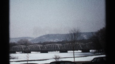 1971: long bridge over frozen lake or river with mountains in background LA