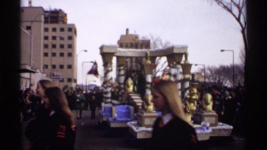 1971: women with long hair walk in front of a parade float covered in gold
