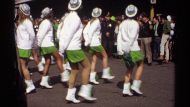 1971: a festival and girls are dancing in front a rally and a statue at the