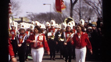 1971: the marching band is out in full storm! going down the street in unison